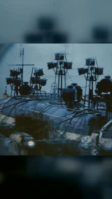 A rig of lights and pipes mounted on a dark war machine at night