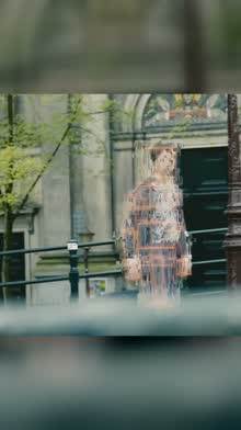 A man outside a building dissolving into square pixels